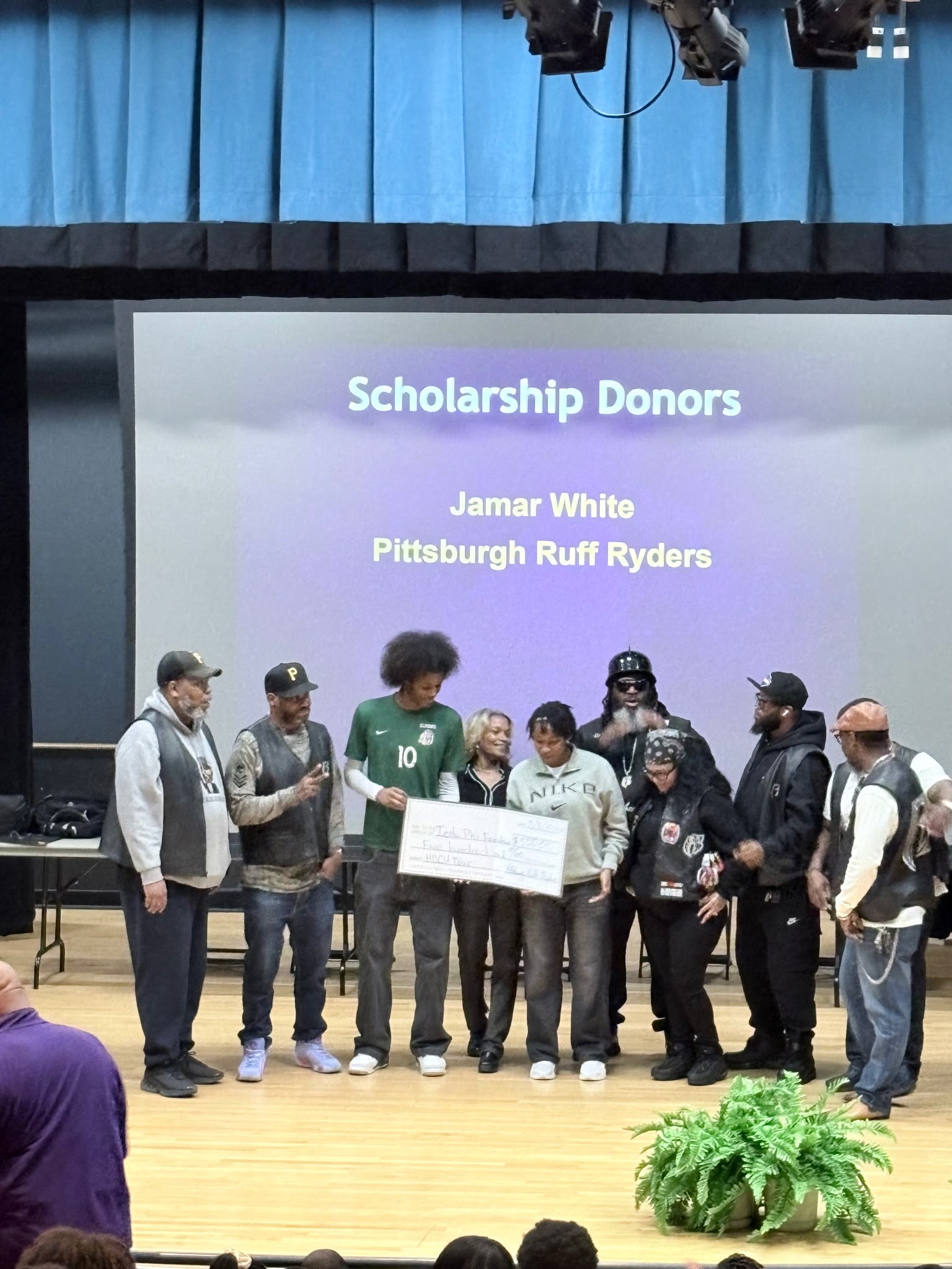 Pittsburgh Ruff Ryders presenting scholarship check on stage