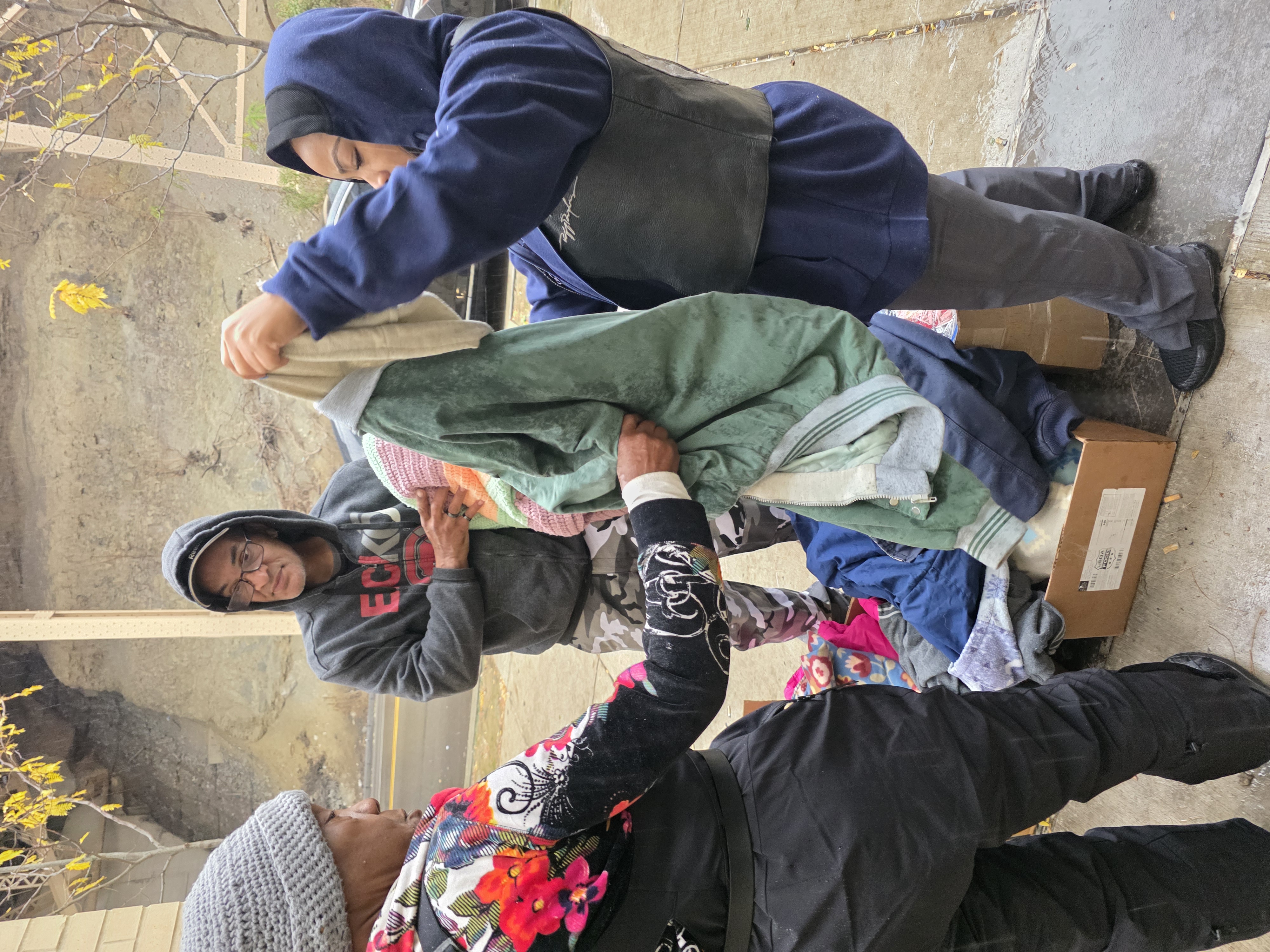 Pittsburgh Ruff Ryders volunteers distributing clothes and blankets on the street