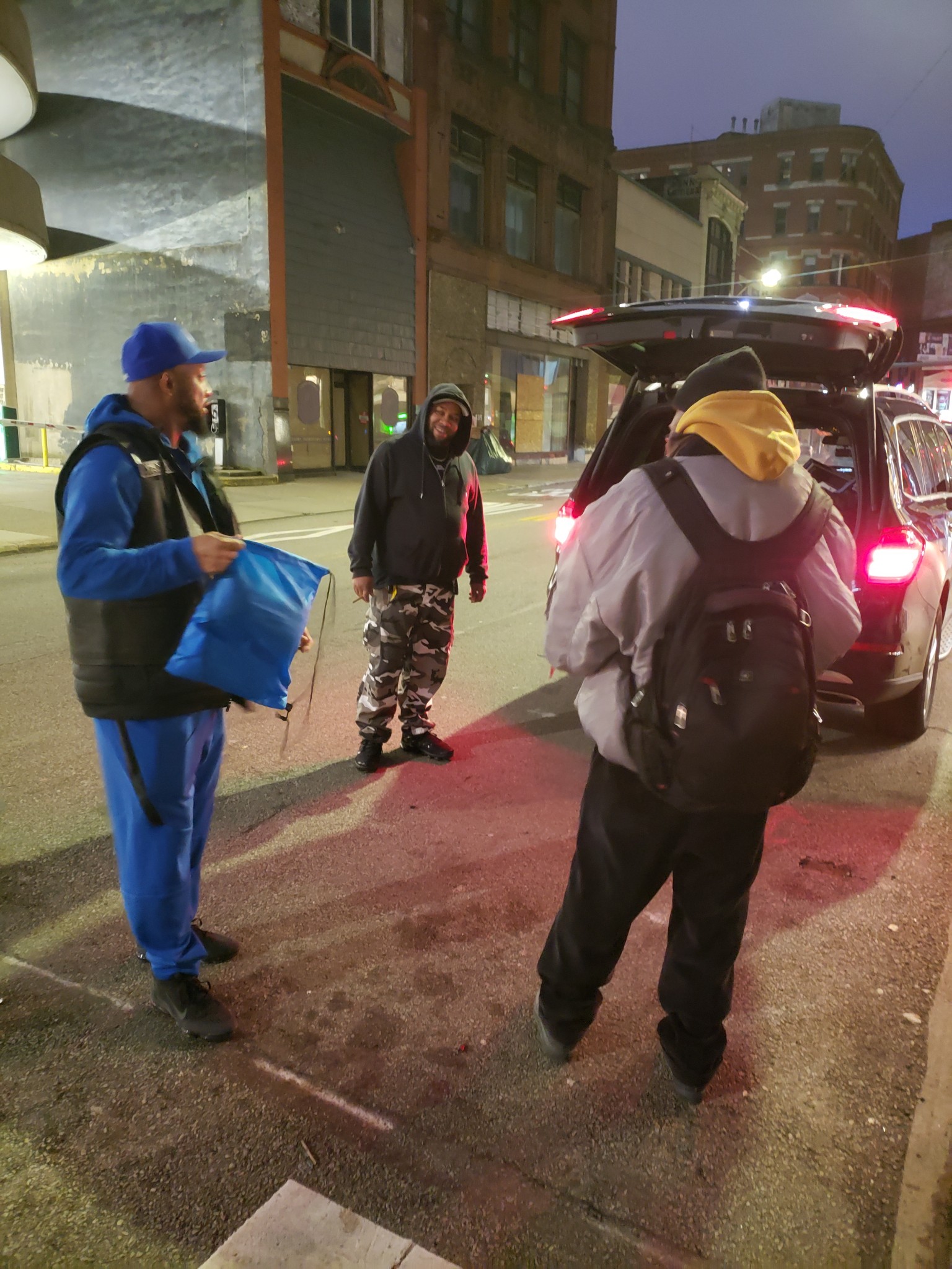 Ruff Ryders volunteers distributing blue supply bags from SUV