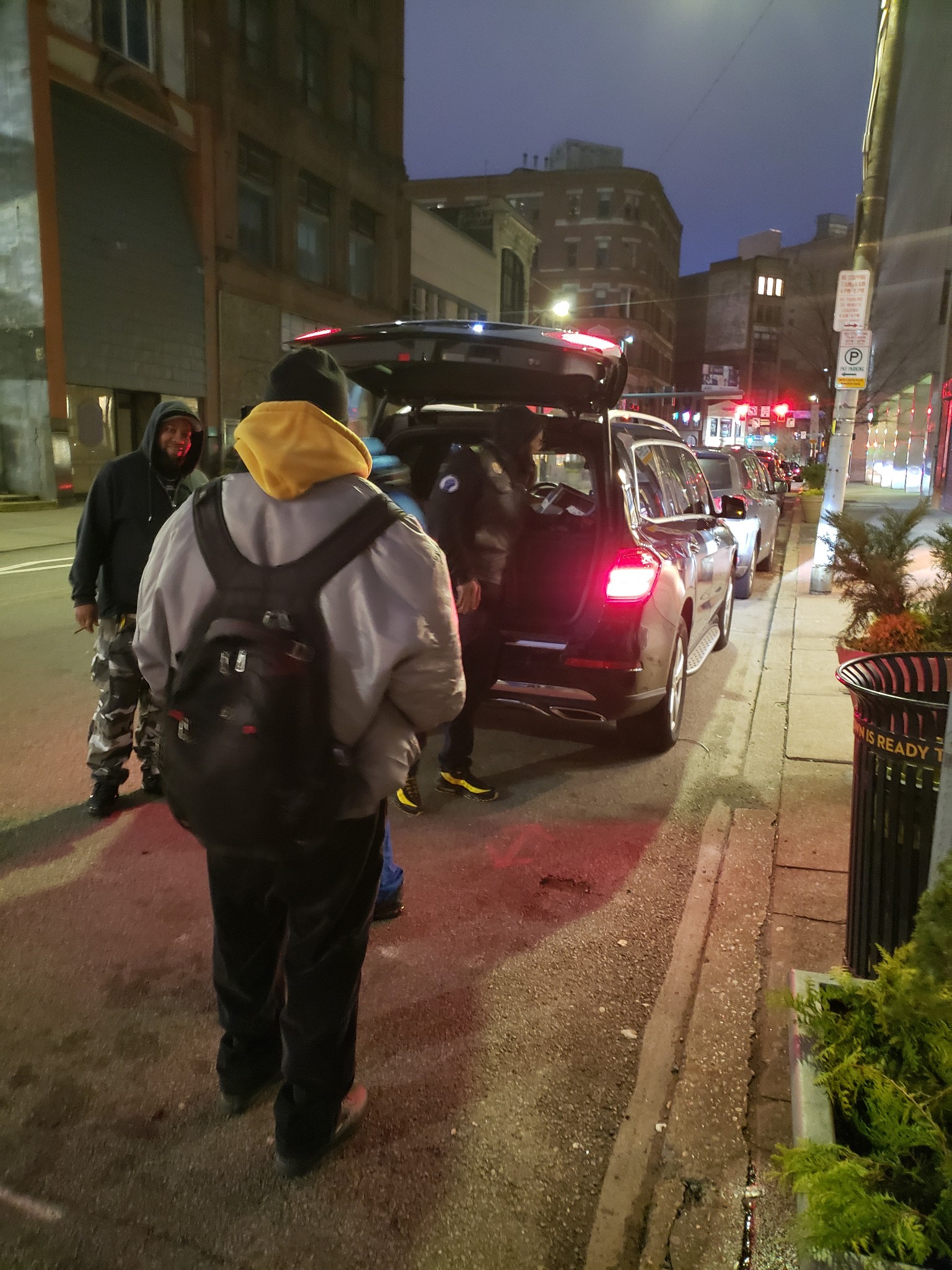 Volunteers gathering around SUV for supply distribution at night